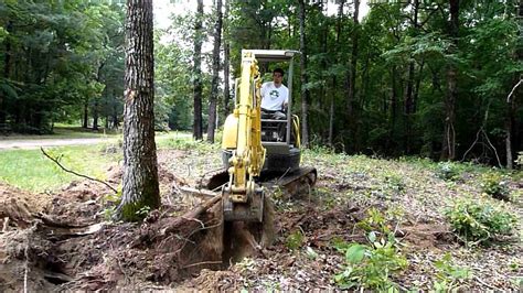 moving trees with mini excavator|how to pull trees with excavators.